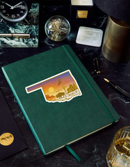 Oklahoma Sticker – Gold Foil State Art with Bison, Sunset, Cabin & Windmill