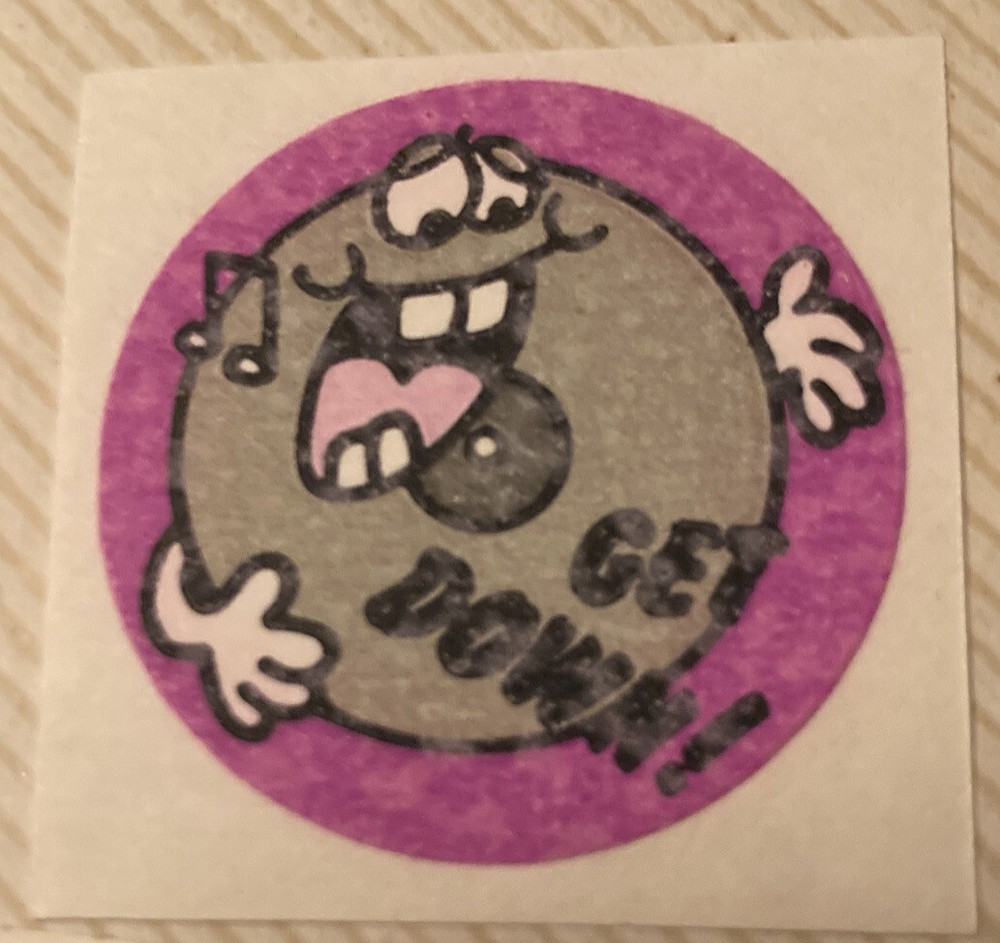 Vintage 1980’s 1.5” matte circle scratch n sniff sticker Get Down!